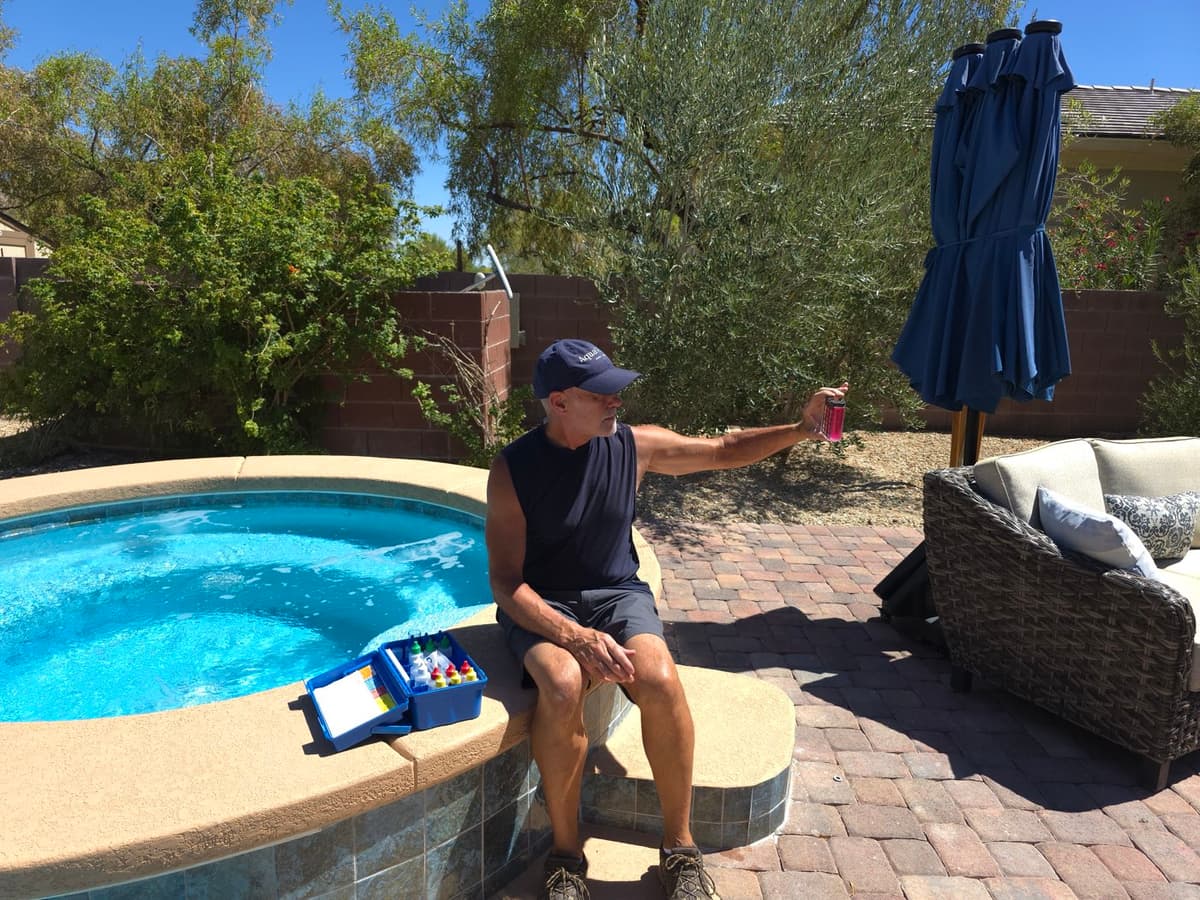 Michael running a full water chemistry test poolside with a drop test kit