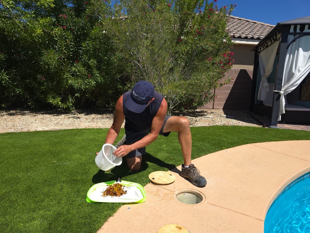 Michael Brown, AquaVision Pool Care Certified Pool Operator, emptying a skimmer basket filled with wind-blown debris at a Las Vegas Valley residential pool