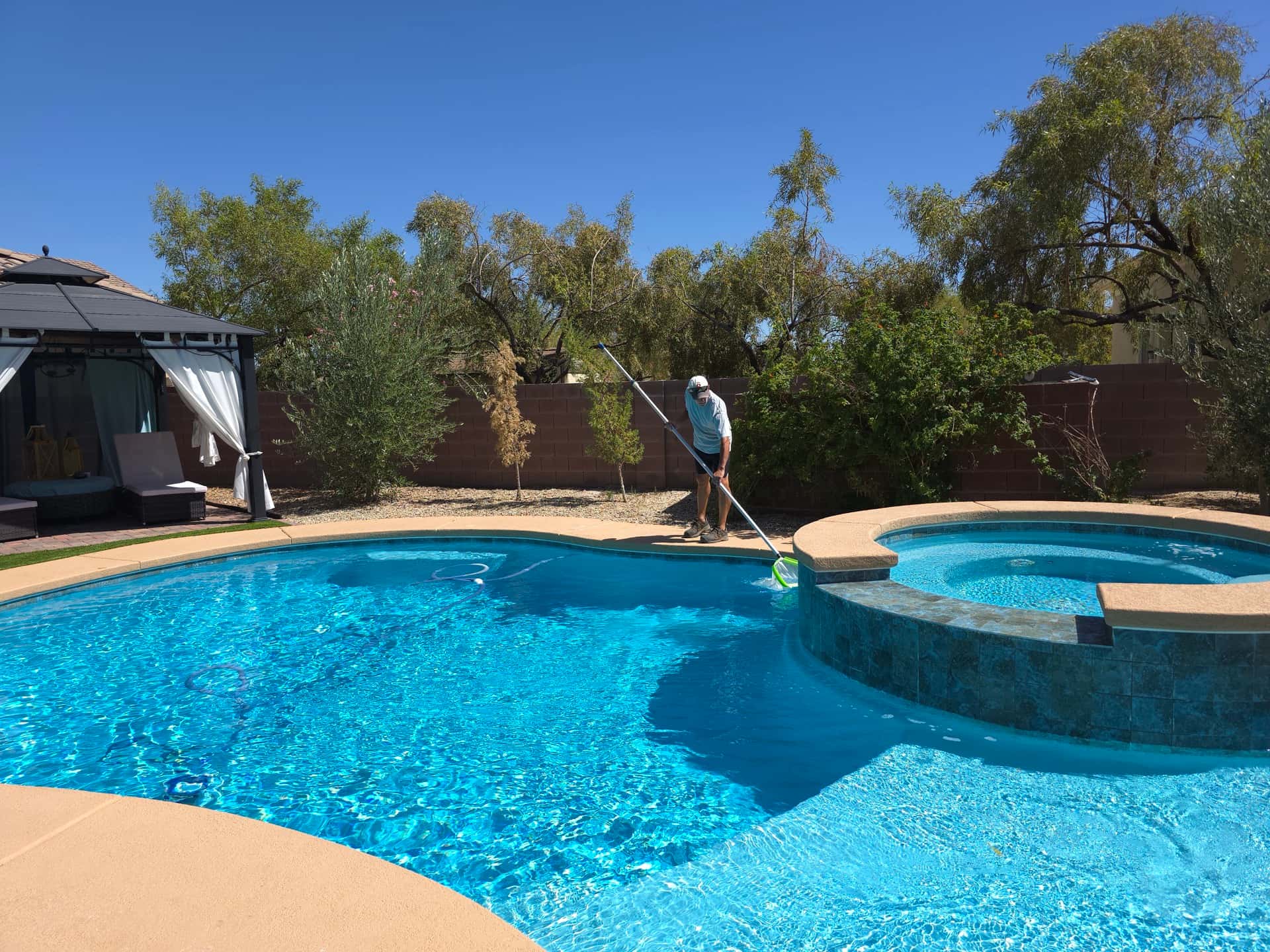 Michael Brown, AquaVision Pool Care owner and Certified Pool Operator, skimming a Las Vegas residential pool