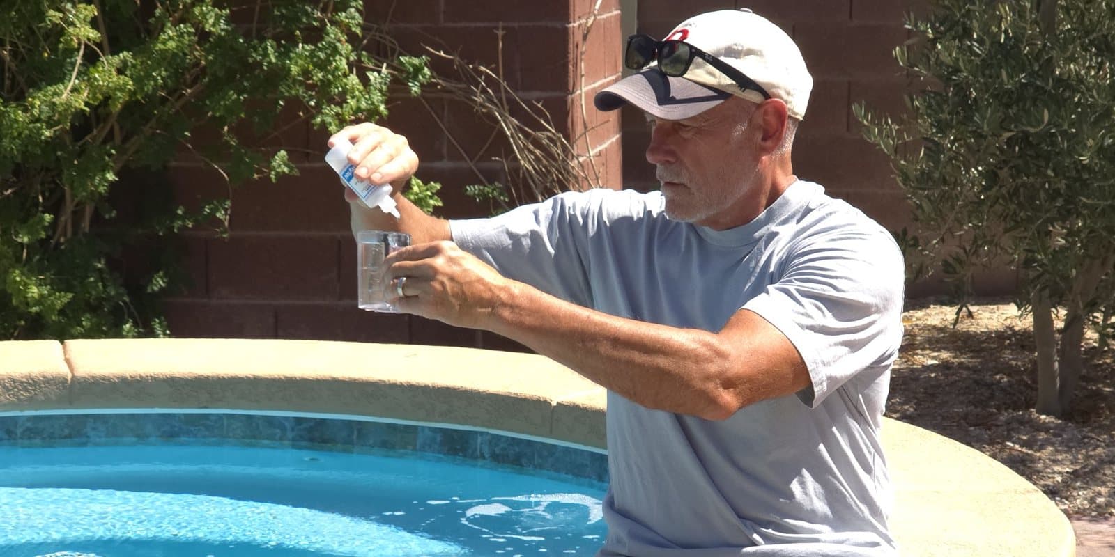 Michael Brown, AquaVision Pool Care owner and Certified Pool Operator, testing pool water chemistry with a drop test kit